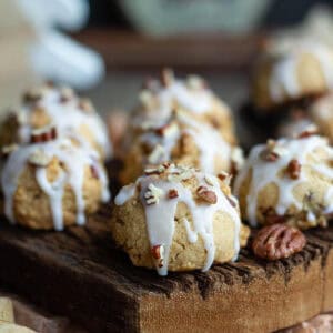 Maple pecan cookies with glaze on a wooden board.