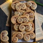 French heart cookies in a small tray on a wooden board with old papers.