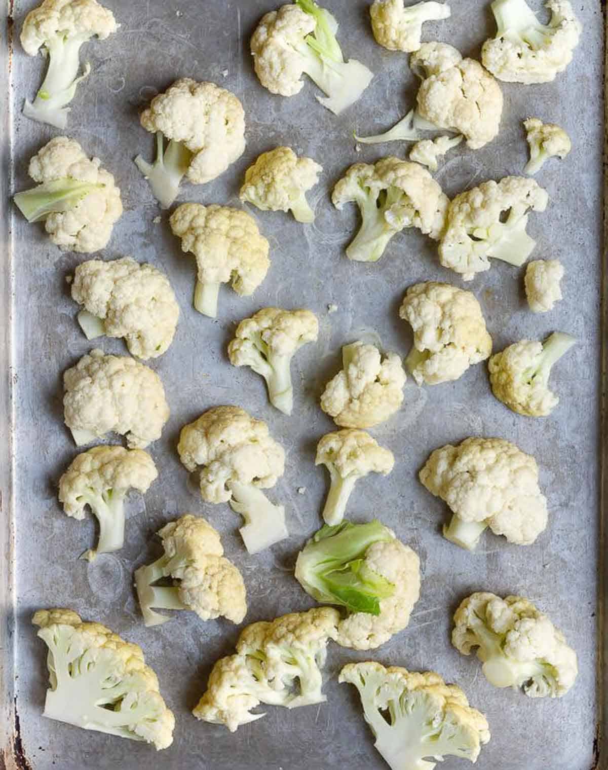 cauliflower florets on a parchment-lined baking tray.