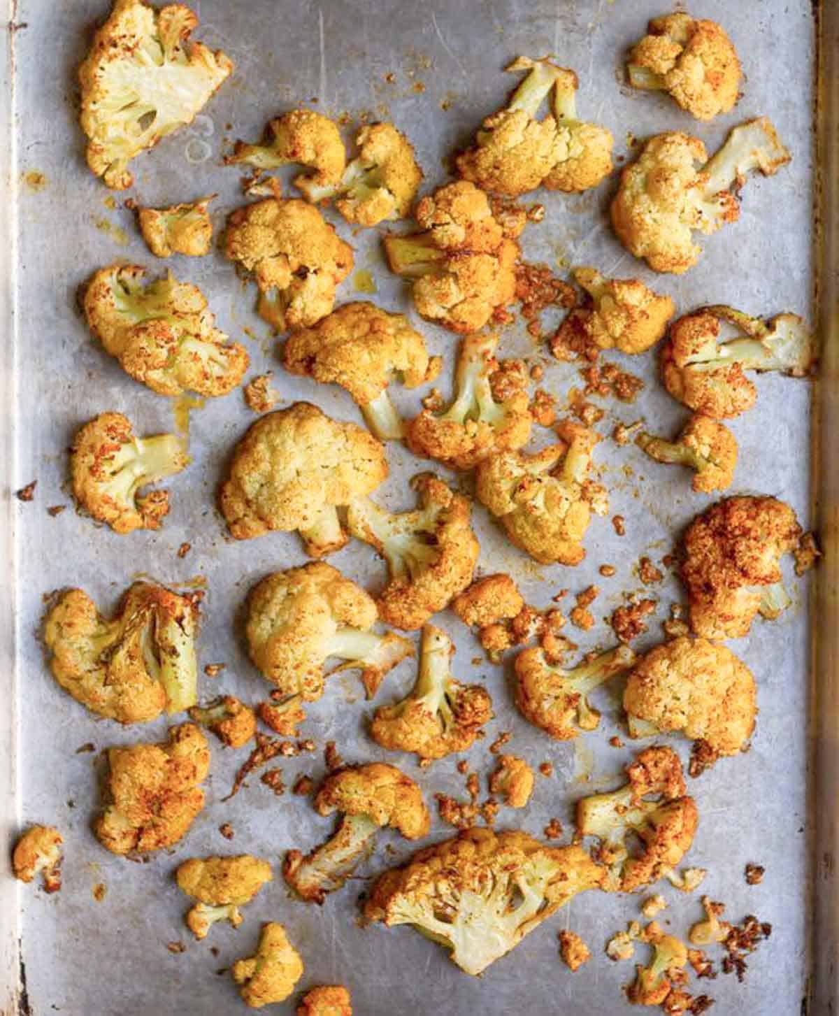 roasted cauliflower florets on a parchment-lined tray.
