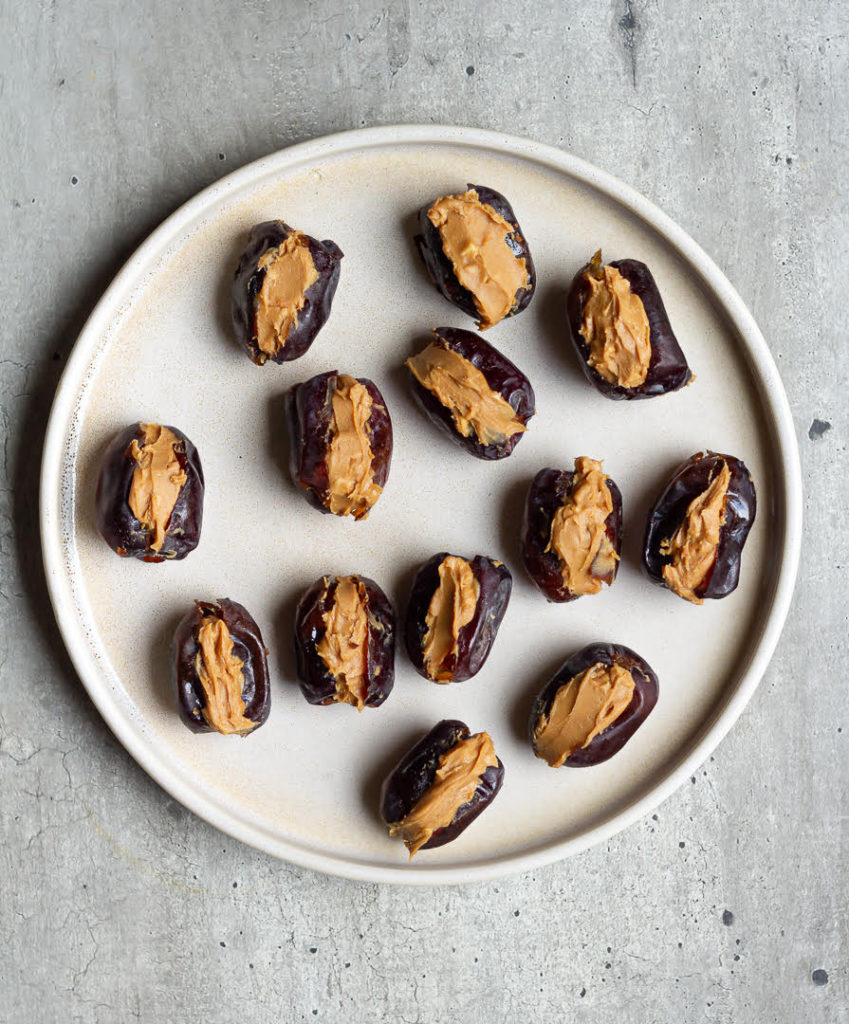 dates stuffed with peanut butter on a plate.