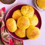 A red platter stacked with pineapple buns.