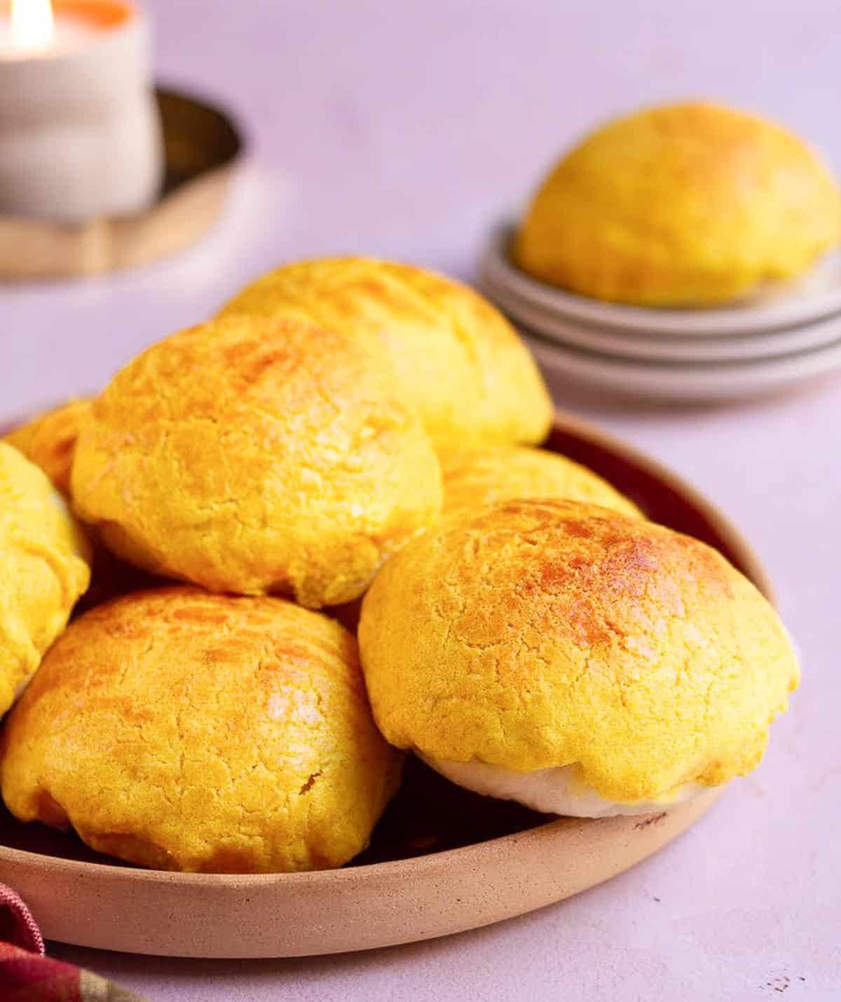 A stack of pineapple buns on a red plate.