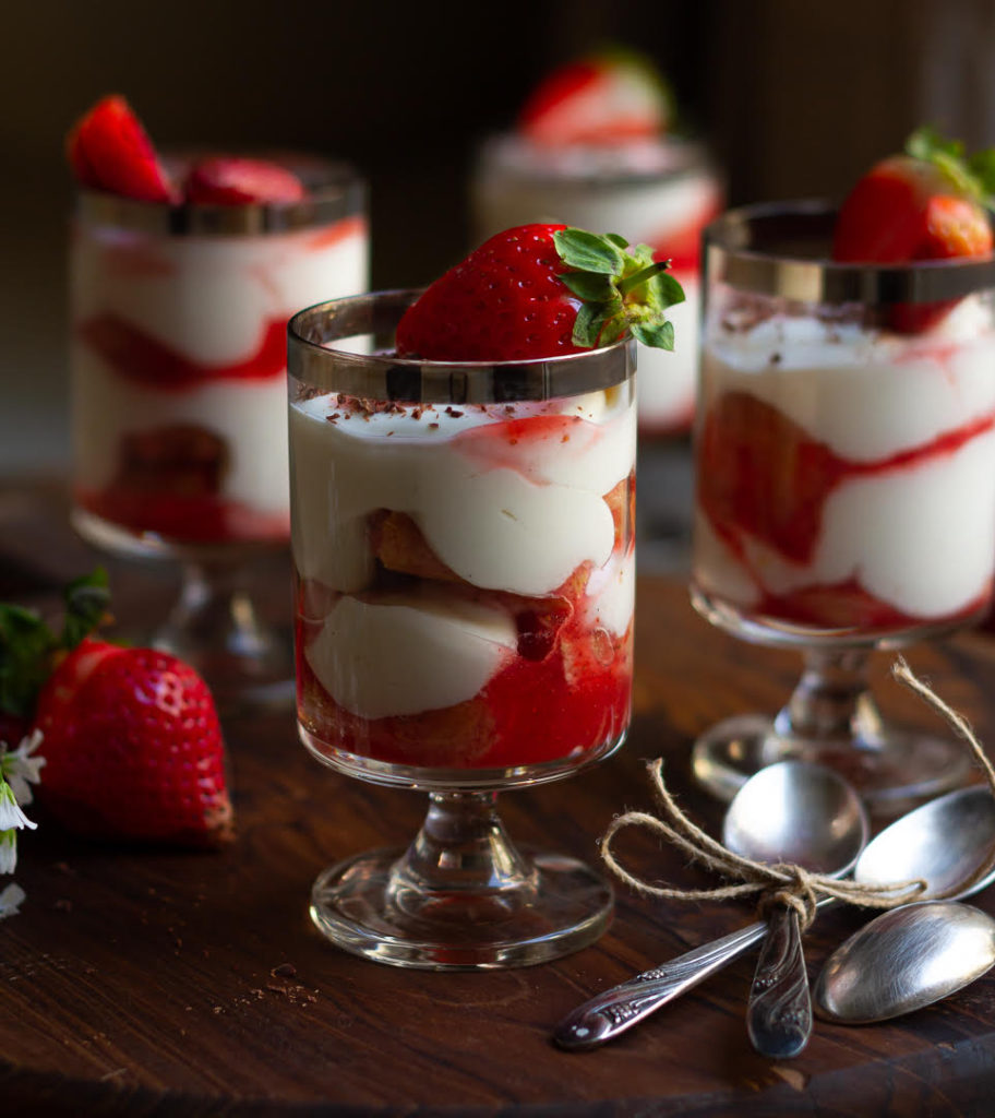 Strawberry Tiramisu served in 4 dessert glasses topped with fresh strawberries.