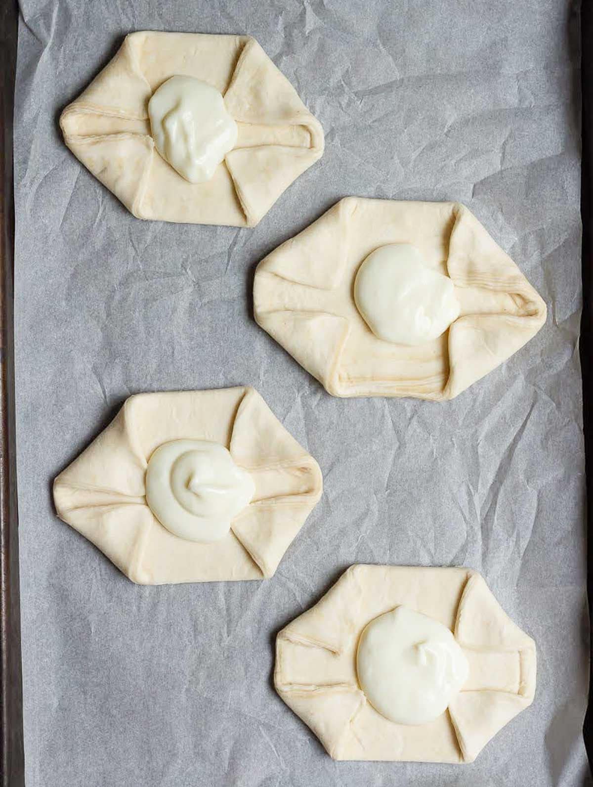 4 puff pastry pieces with cream cheese in the center.