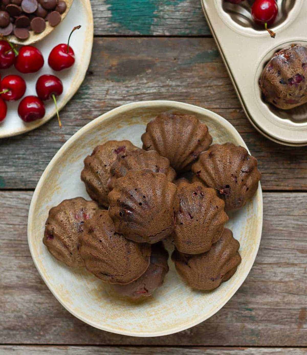 Chocolate cherry madeleines on a plate.