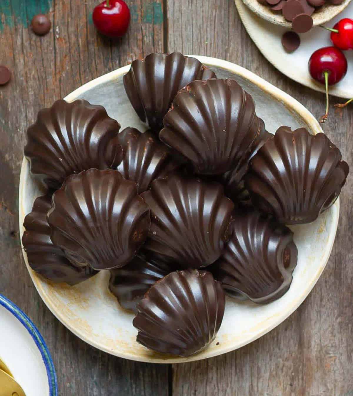 Chocolate coated madeleines on a plate.