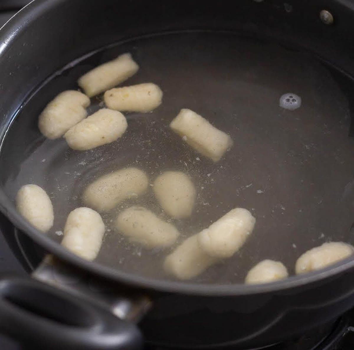 Gnocchi cooking in a pot of boiling water.