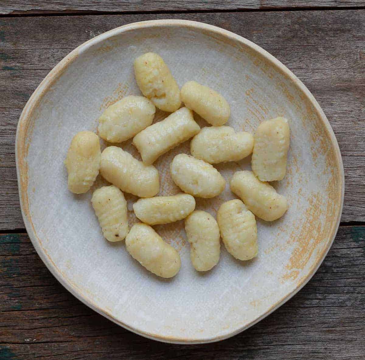 Cooked gnocchi on a ceramic plate.