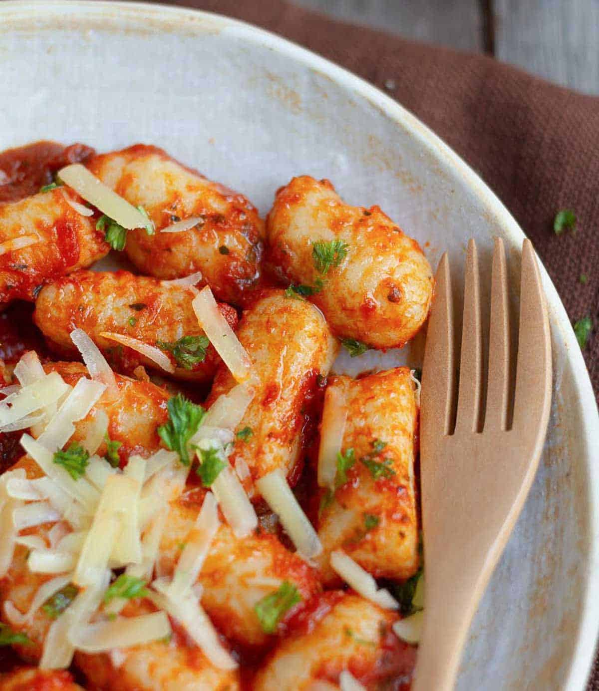 Gnocchi with tomato sauce on a plate with a fork.