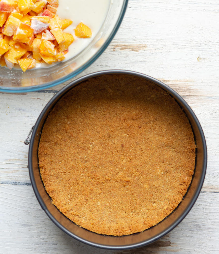 Crust for cheesecake in a cake pan.