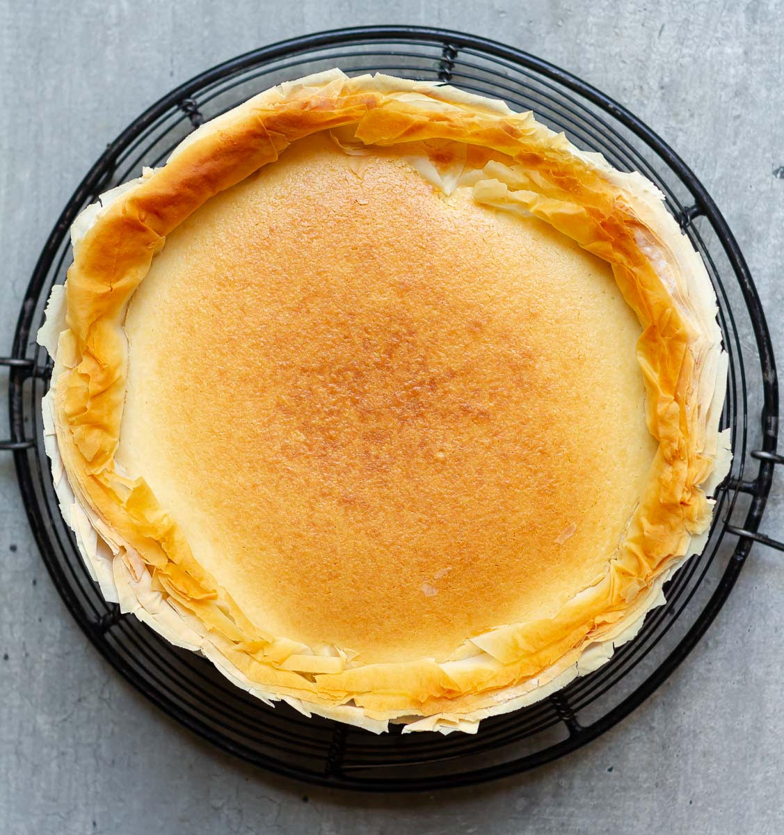 Baked cheesecake on a wire rack.