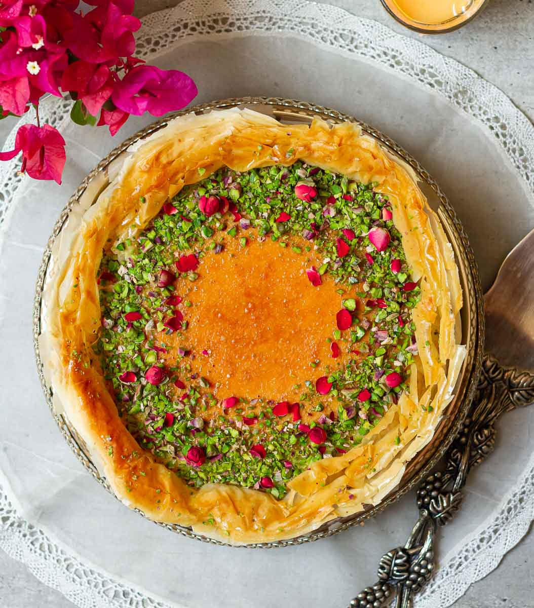 Baklava-style cheesecake on an embroidered placemat with a cake server on the side.