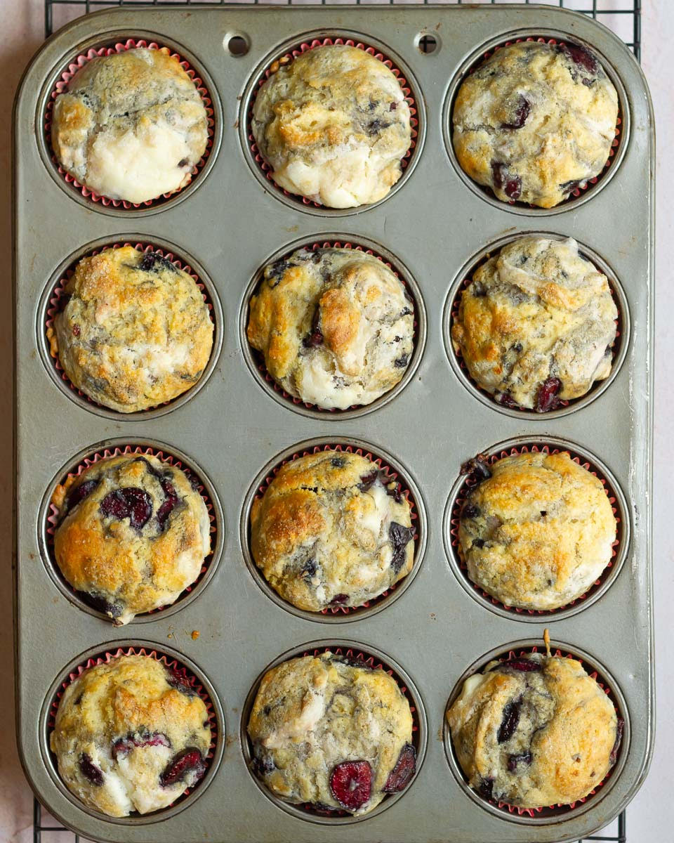 Baked cherry cheesecake muffins in a muffin tray.