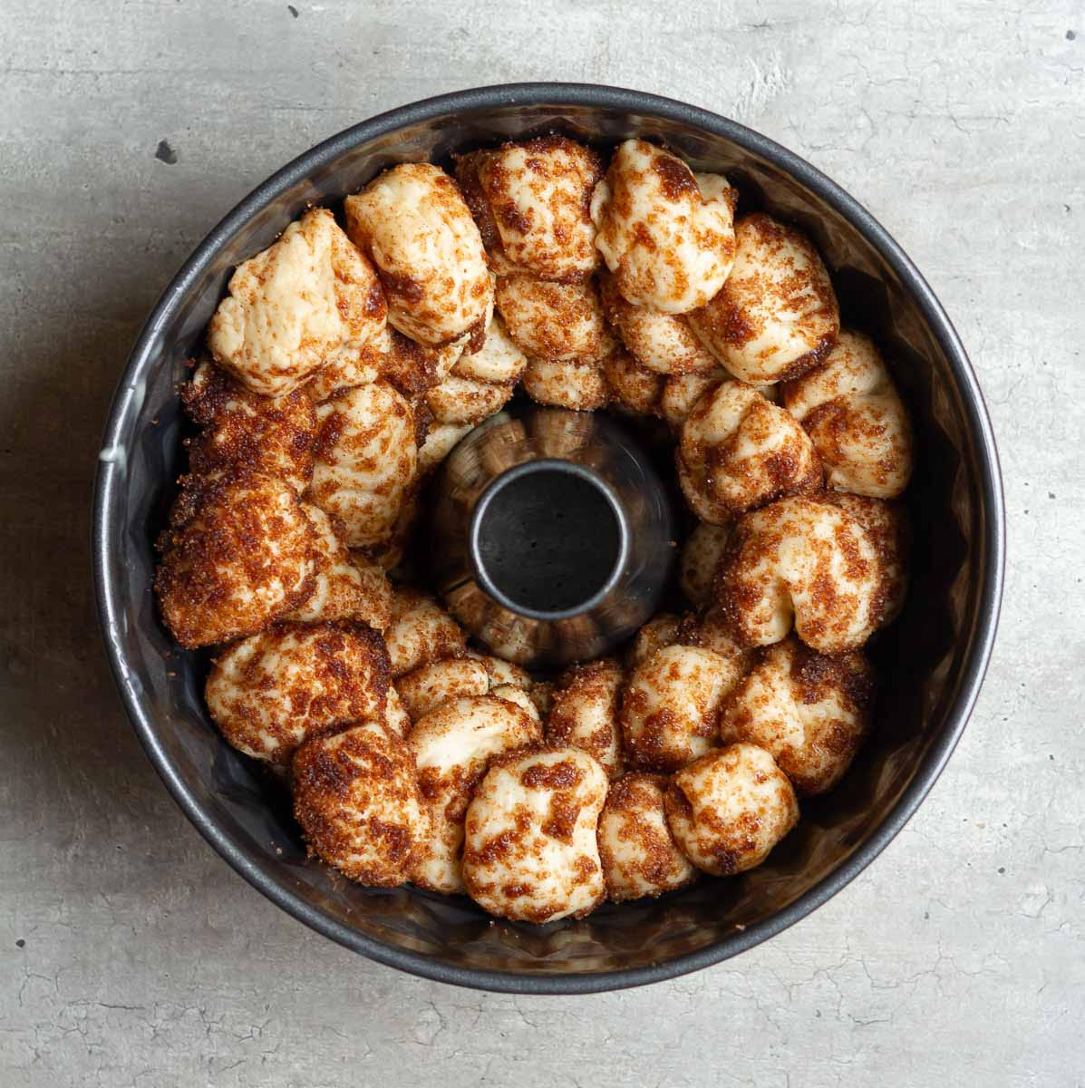 Dough pieces layered in a Bundt pan.