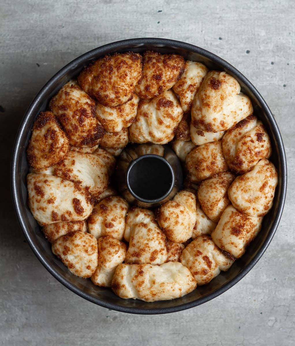 Proofed monkey bread dough in a bundt pan.
