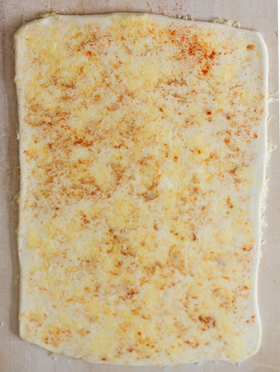 Rolled out puff pastry with cheese and seasonings