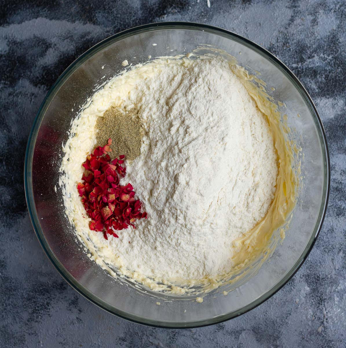 Mix in flour, rose petals, cardamom powder into the butter- sugar mixture