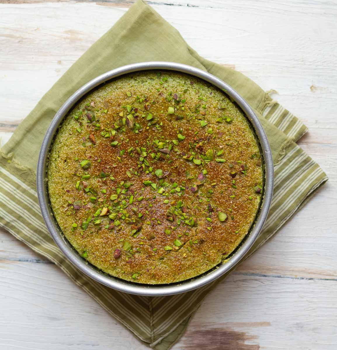 Baked pistachio cake in a cake tin.