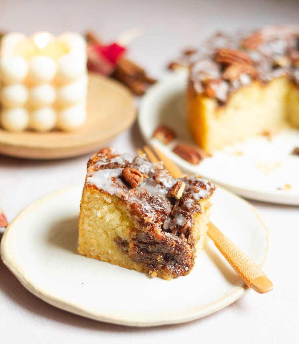 A slice of cake on a small plate with a wooden fork.
