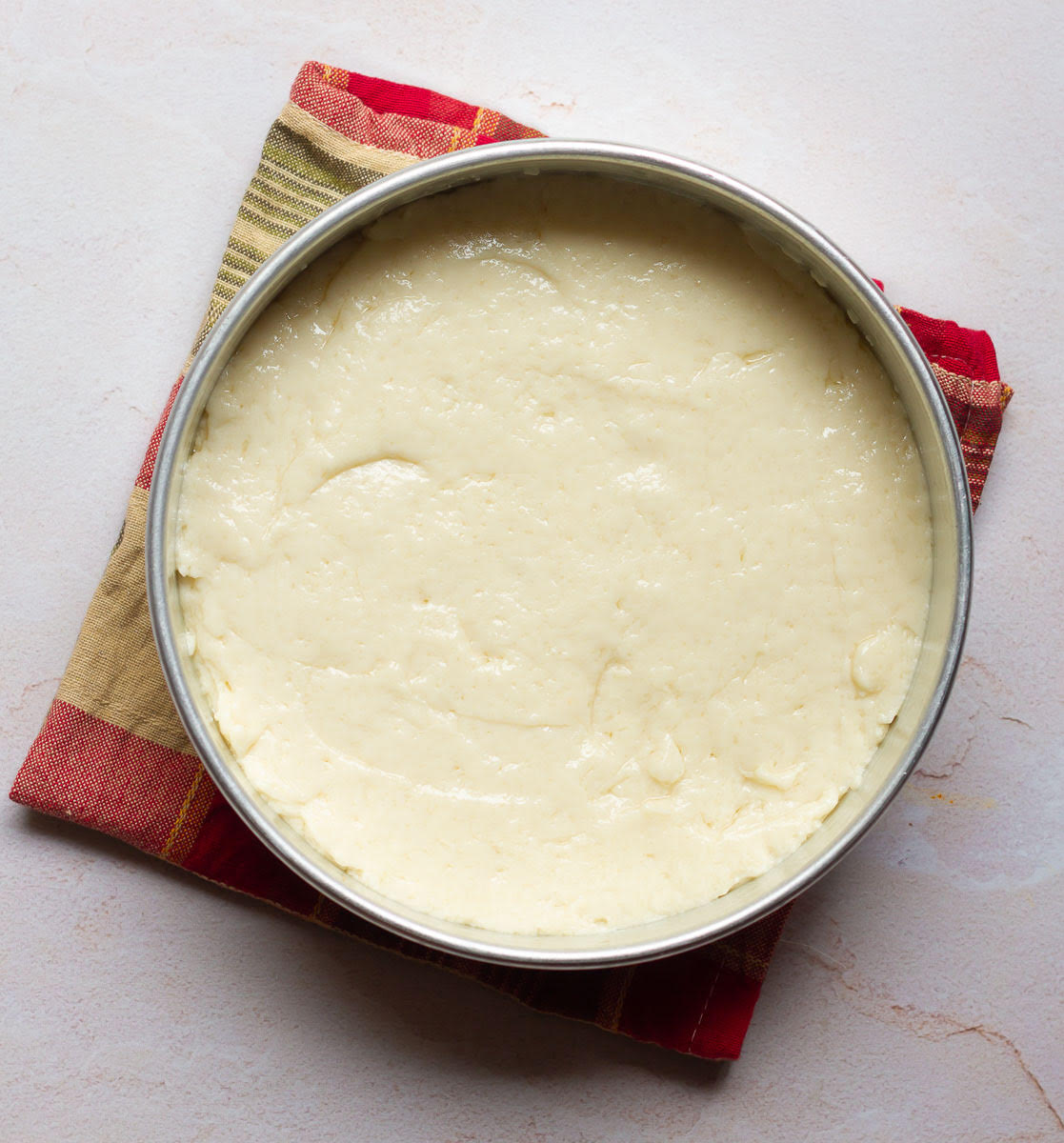 Cake batter in a round cake pan.