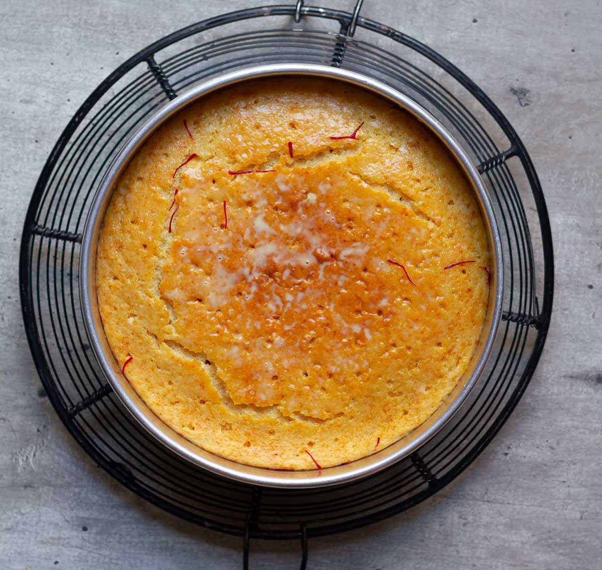 Pour the saffron milk over the saffron cake