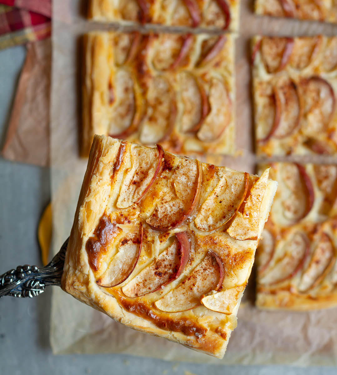 A slice of apple puff pastry on a cake server.