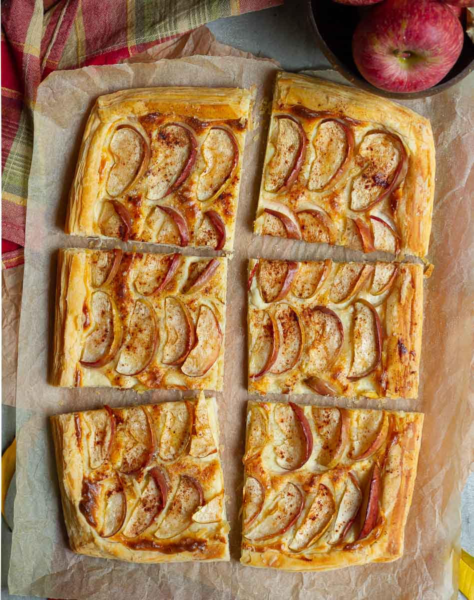 Apple tart cut into 6 squares on a parchment paper.