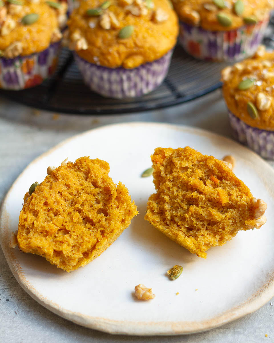 A muffin cut in half on a small plate.