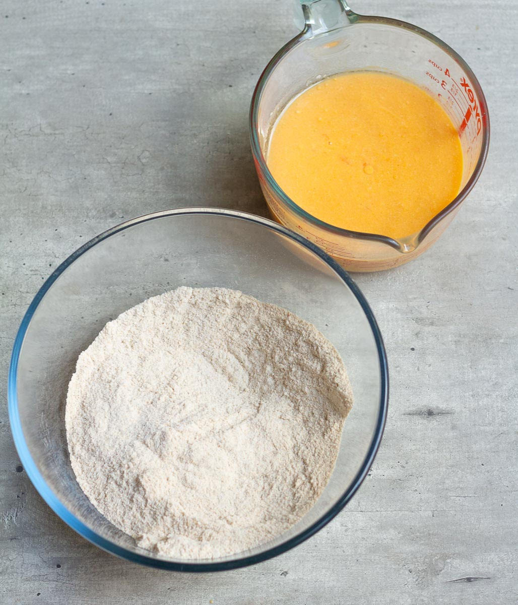Dry ingredients in a mixing bowl and wet ingredients in a measuring cup.