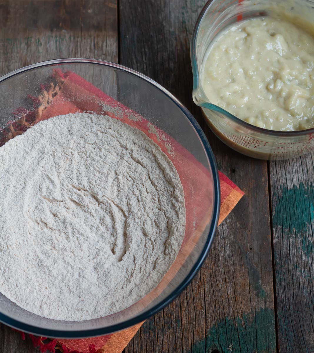 wet and dry ingredients for the sweet potato bread in mixing bowls.