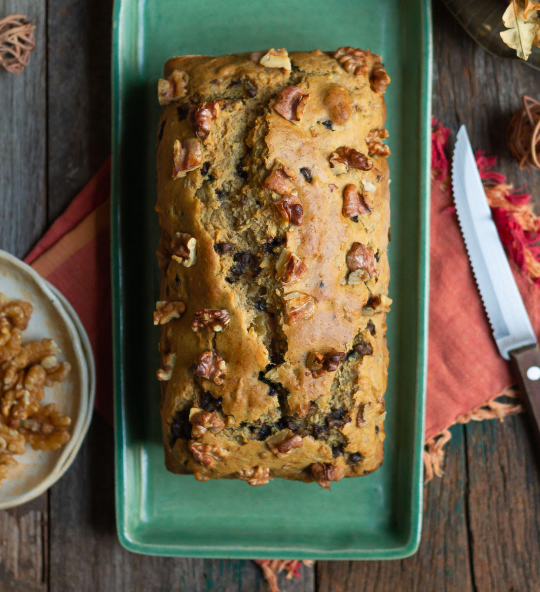Sweet potato bread topped with walnuts on a green platter.