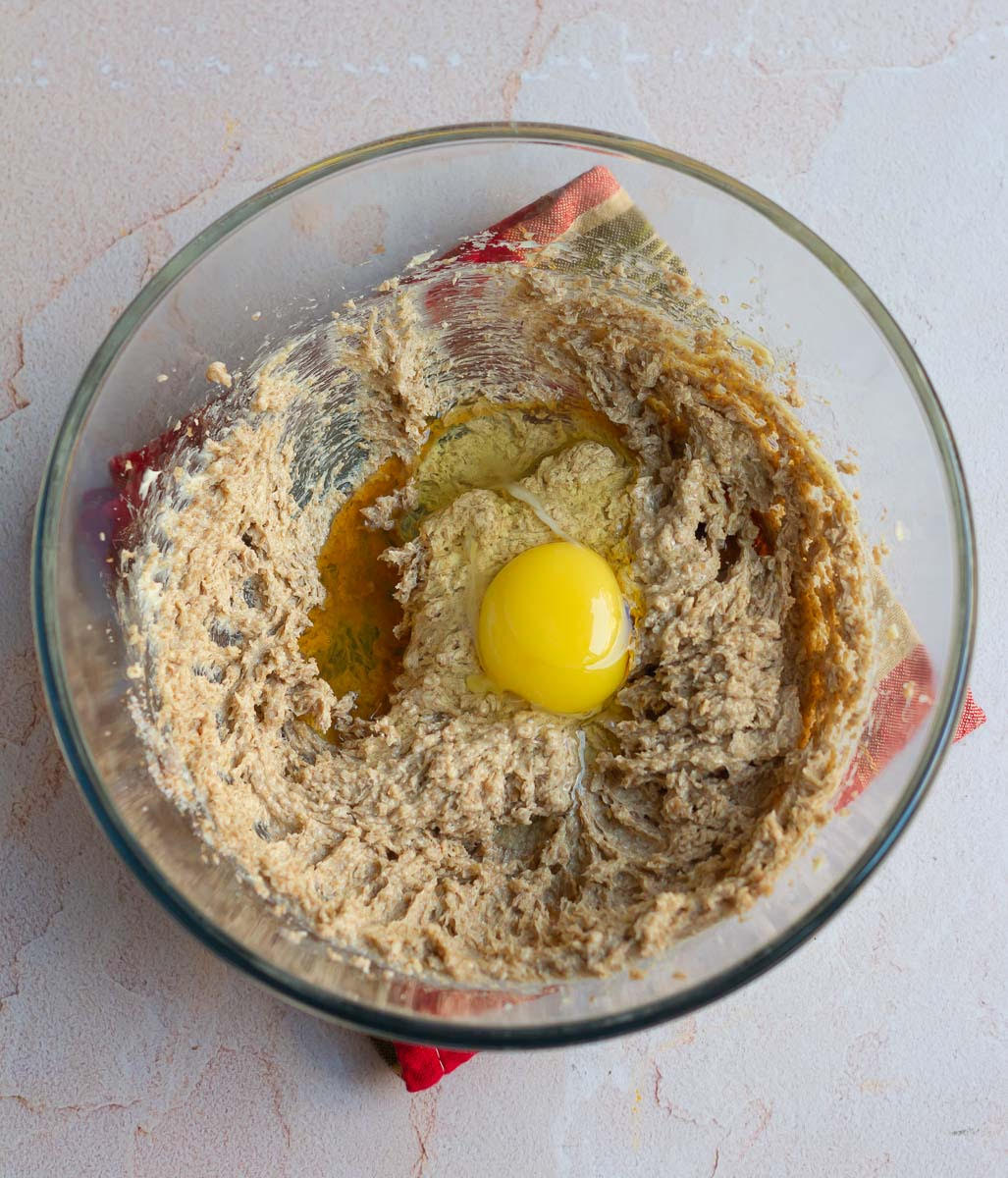 Eggs on top of beaten butter-sugar mixture in a mixing bowl.