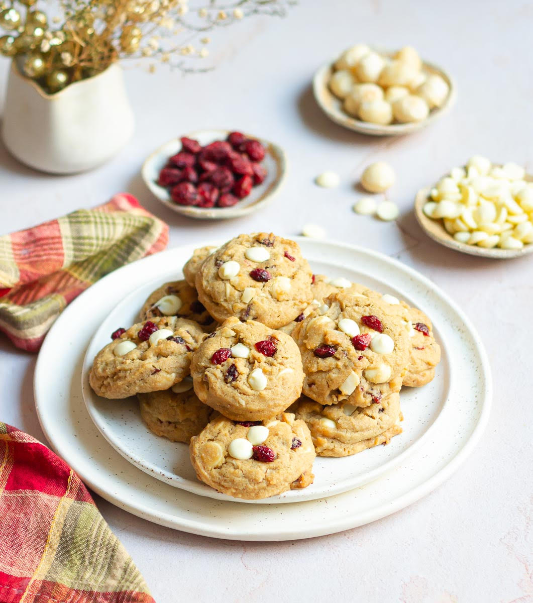 White Chocolate Cranberry Cookies on a serving platter with ingredients in the background.