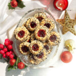 Thumbprint cookies on a platter surrounded by holiday decor.