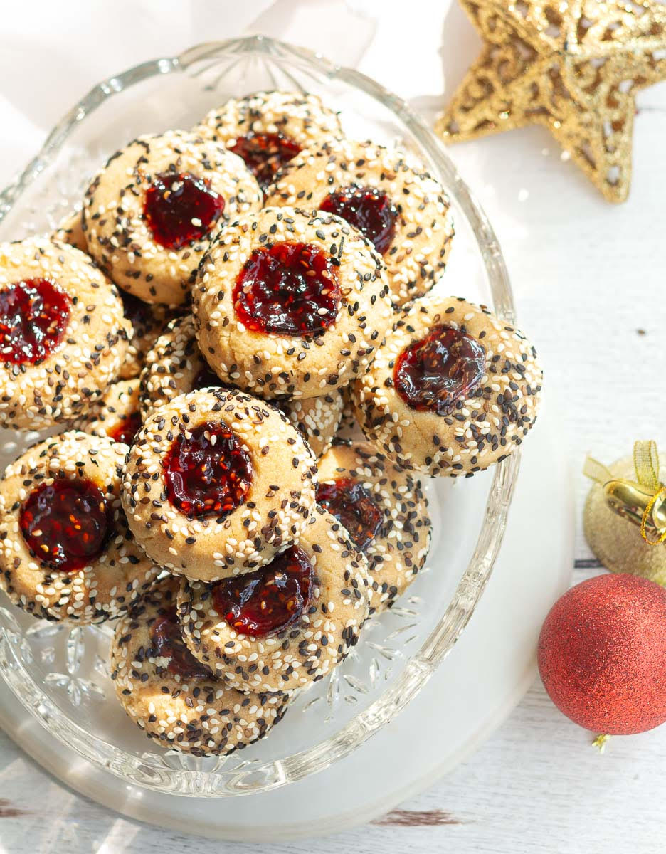 Jam cookies on a platter with Christmas decor around.