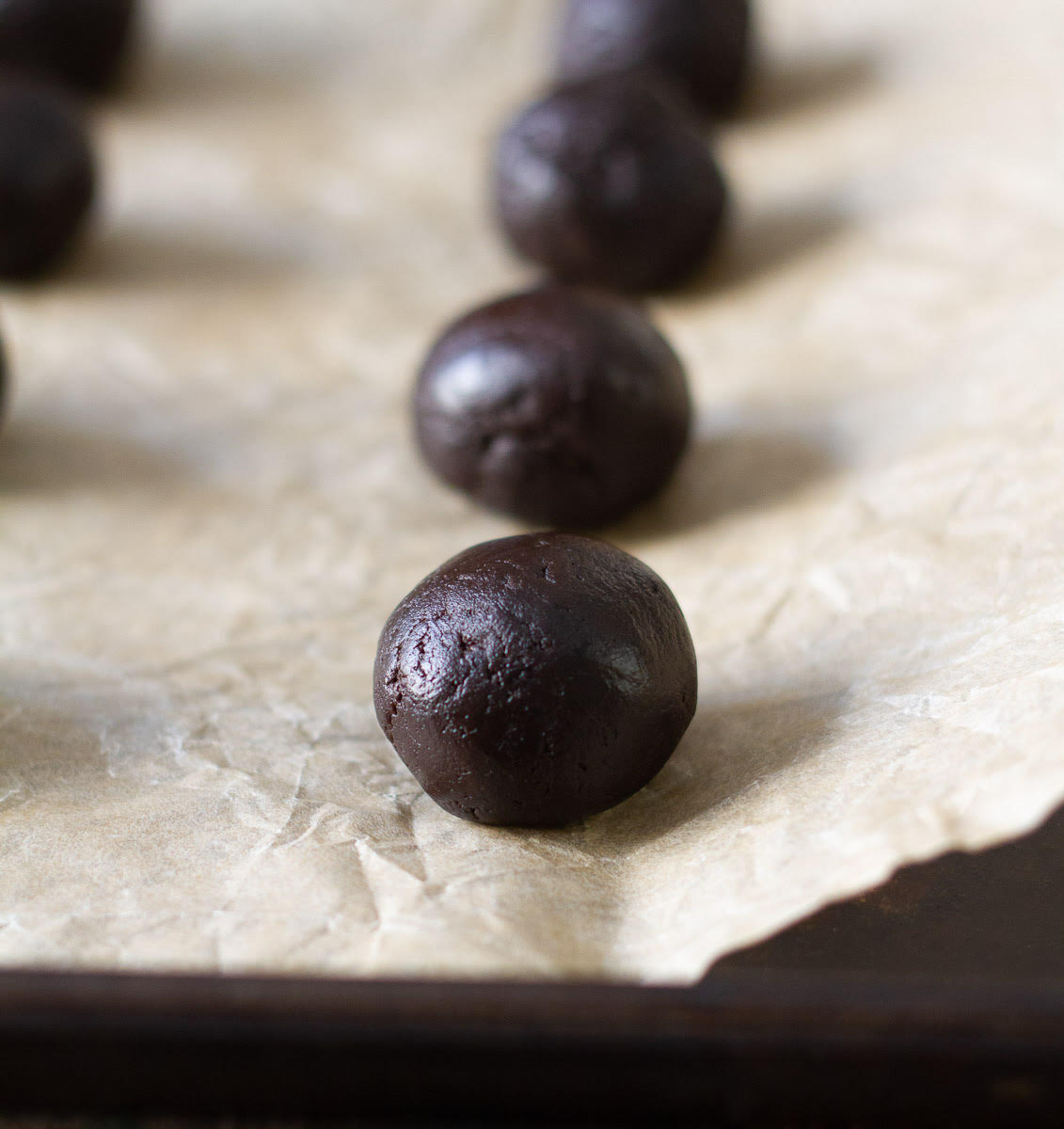 cookie dough balls on a parchment paper.