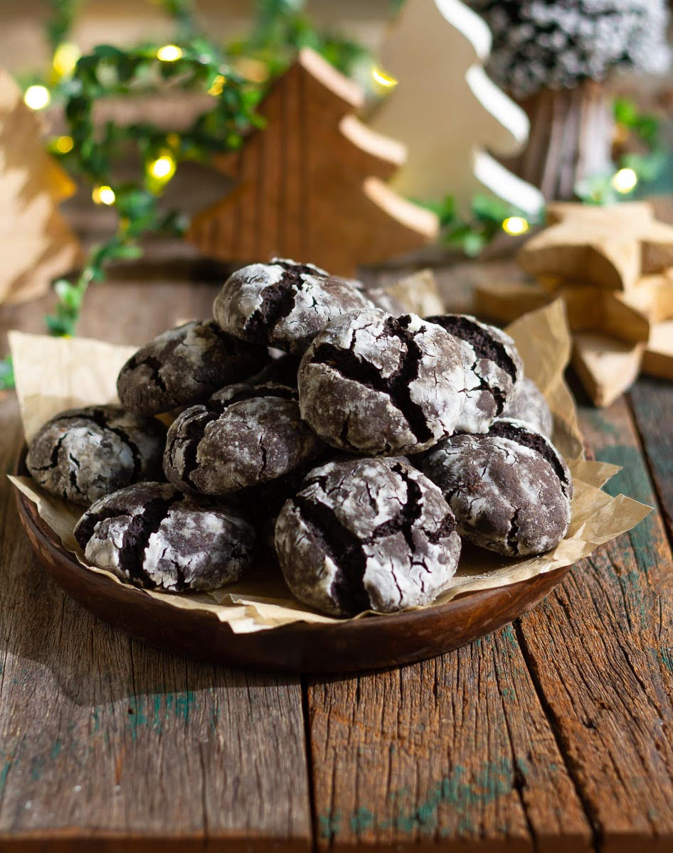 Chocolate cookies stacked up on a wooden platter.