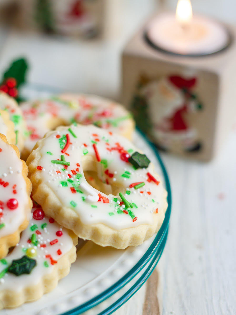 Decorated Christmas wreath cookies on a plate.