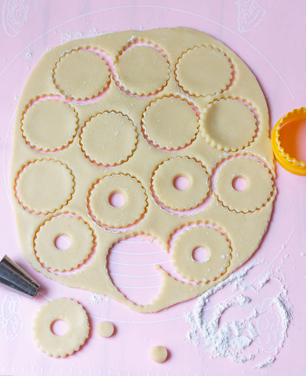 Rolled out cookie dough with big and small round shapes cut out.
