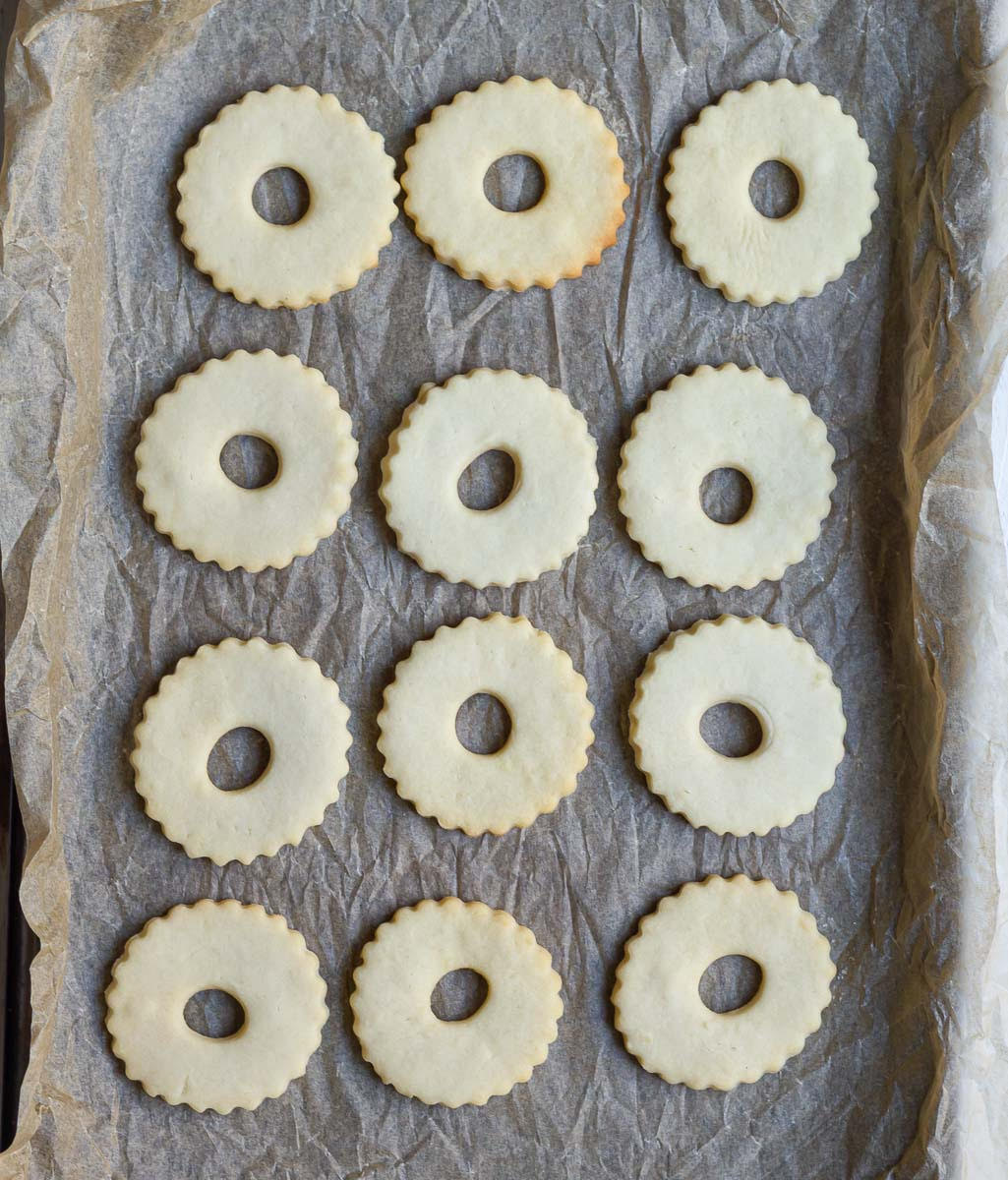 Baked wreath cookies on a parchment-lined tray.