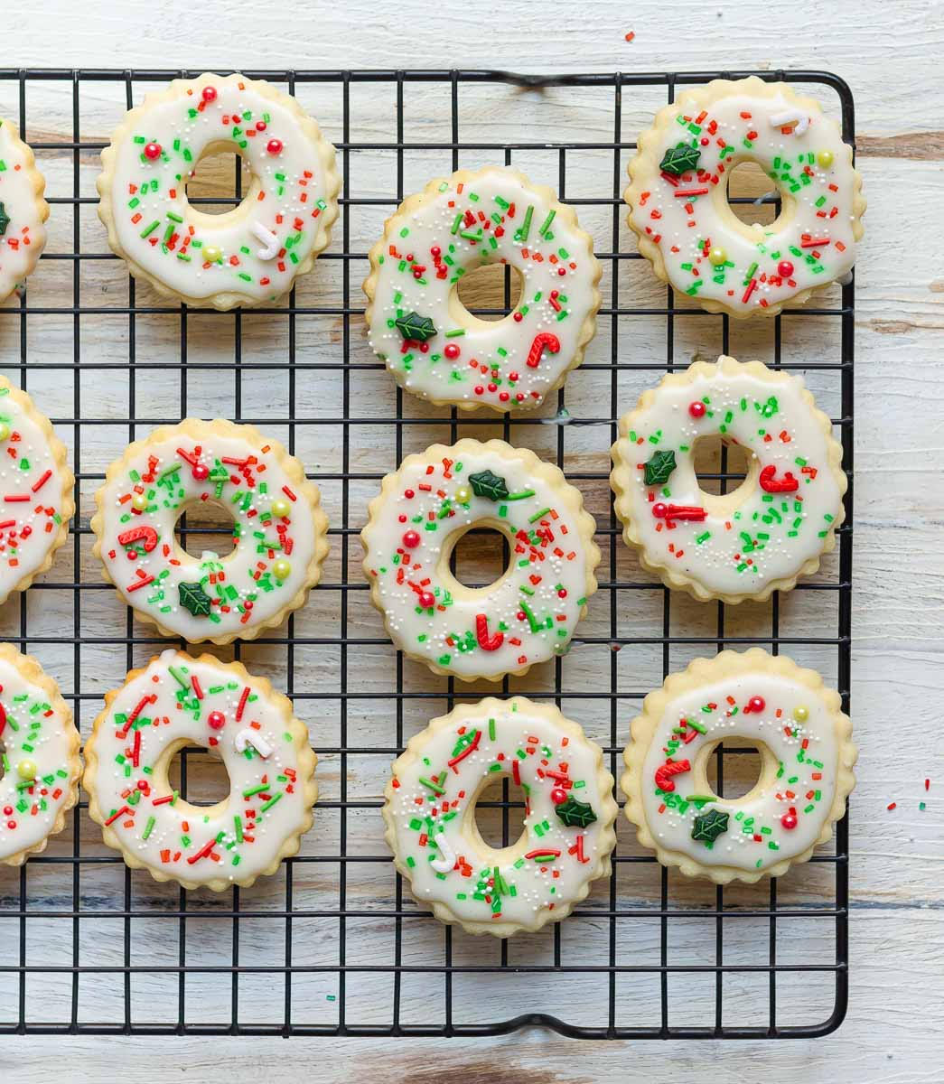 Wreath cookies decorated with lemon glaze and red, green, and white sprinkles.