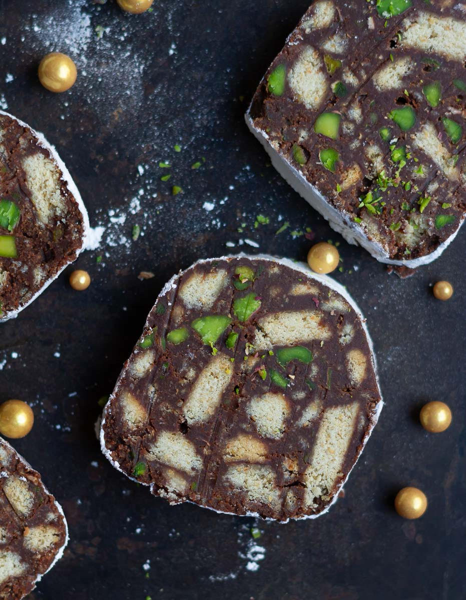 Slices of chocolate salami on a black tray.