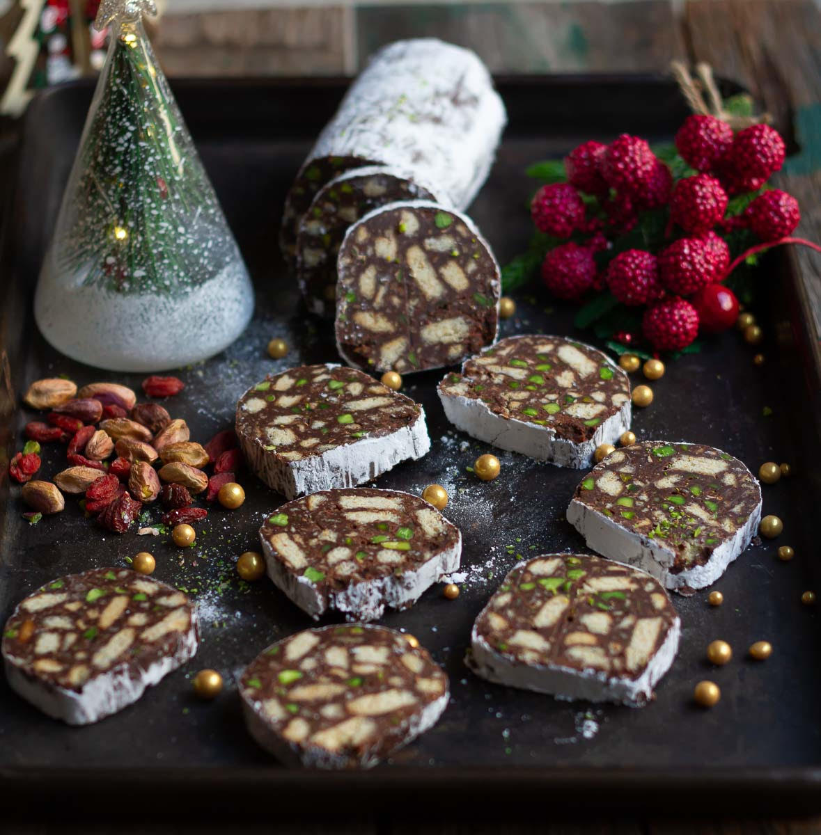 Slices of chocolate salami on a black tray.