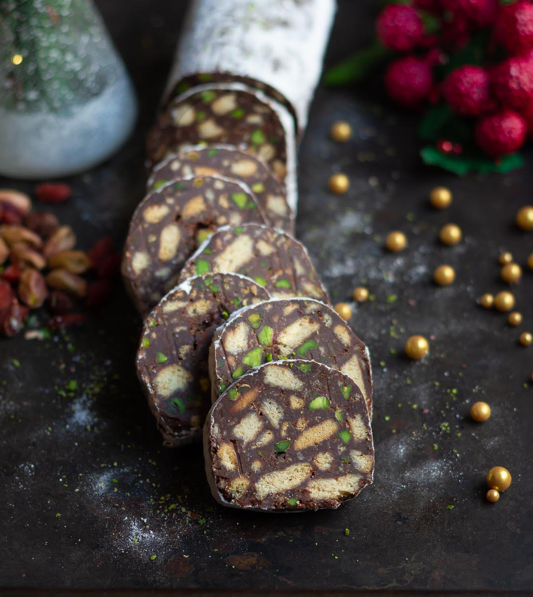 Chocolate salami log and slices on a black tray.