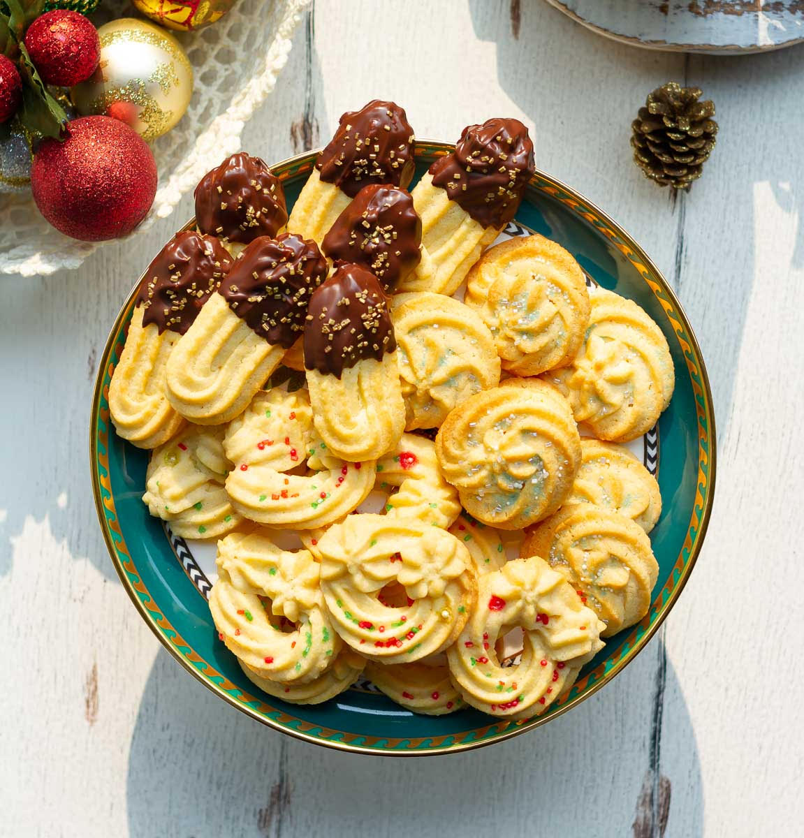 A platter of assorted butter cookies decorated with sprinkles and dipped in chocolate.