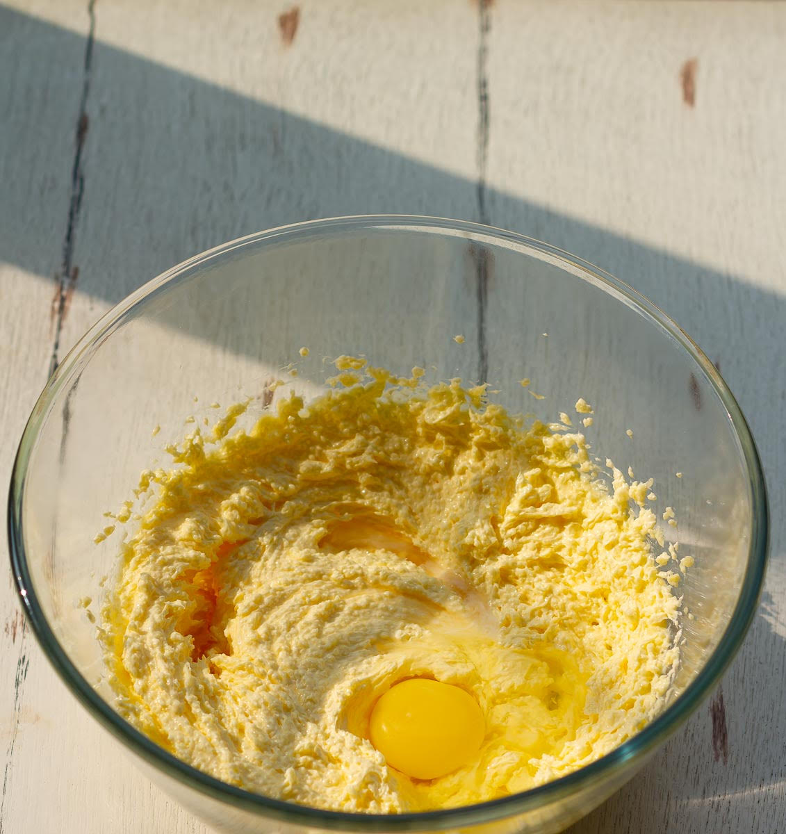 Mixture of butter, sugar, egg, vanilla extract, and almond extract in a mixing bowl.