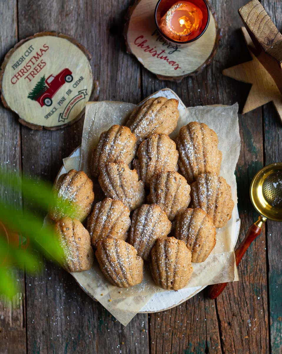 madeleines on parchment paper with christmas decor around.