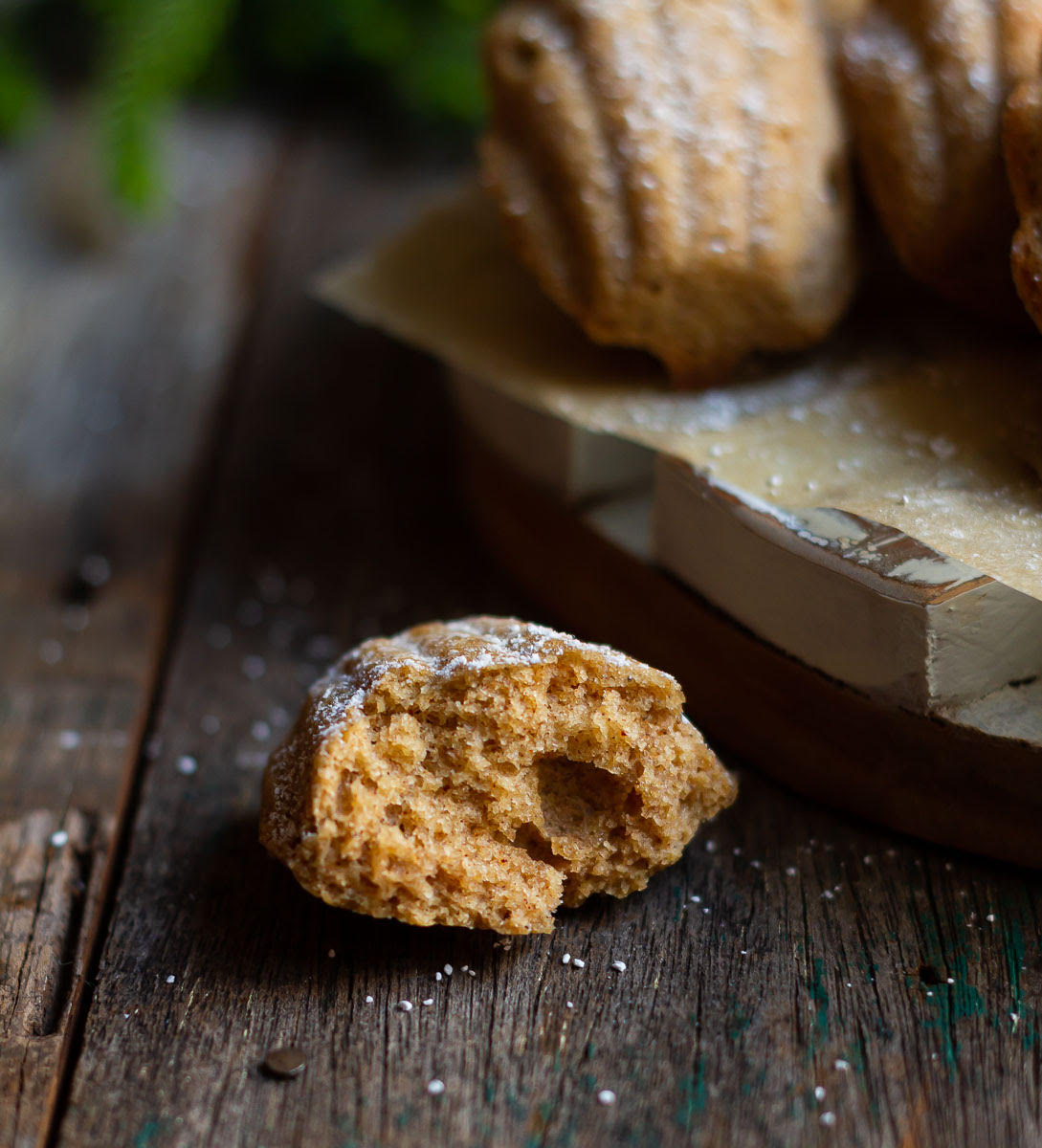 Half a madeleine on a wooden surface.