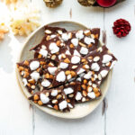 pieces of chocolate bark with marshmallows and almonds on a plate.